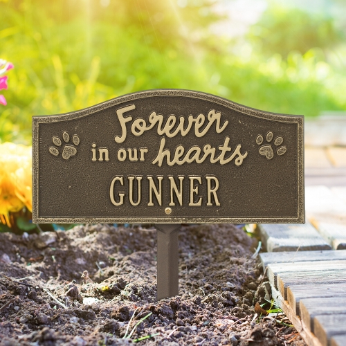 Forever in Our Hearts Memorial Yard Sign in Antique Brass Staked on the Sidewalk lit up by the Bright Sunlight