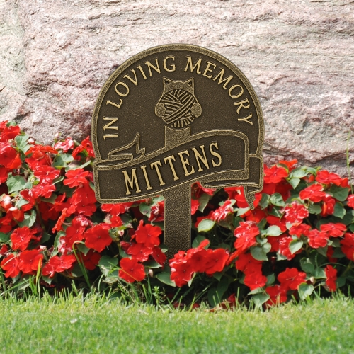 Cat with Yarn Memorial Yard Sign in Antique Brass in the Garden Surrounded by Bright Red Flowers
