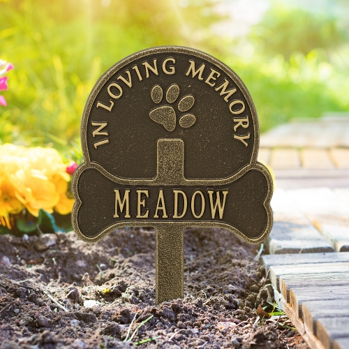 Paw & Bone Memorial Yard Sign in Antique Brass Staked on the Sidewalk lit up by the Bright Sunlight